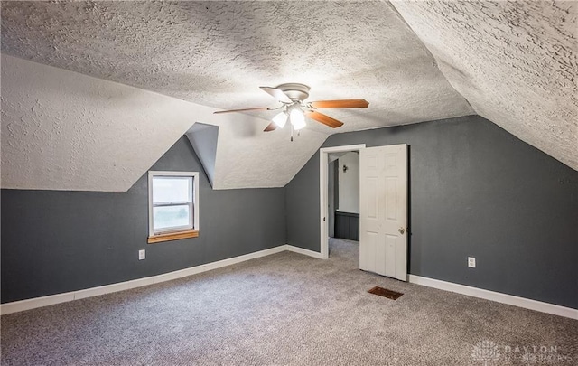 bonus room with lofted ceiling, ceiling fan, carpet floors, and a textured ceiling