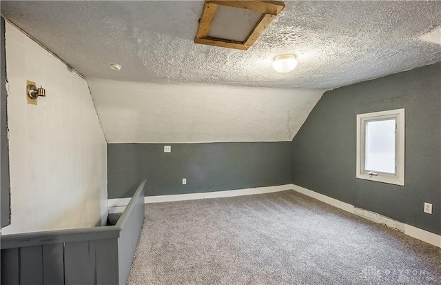 bonus room with a textured ceiling, carpet floors, and vaulted ceiling