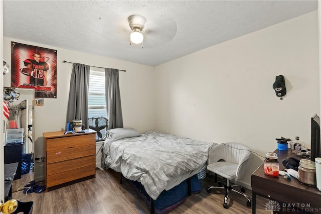 bedroom featuring a textured ceiling, dark hardwood / wood-style floors, and ceiling fan