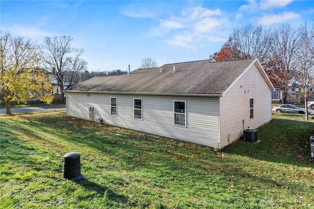 view of side of home with a yard and central AC unit