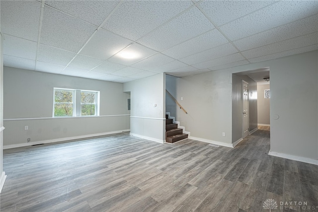 basement featuring a paneled ceiling and hardwood / wood-style flooring