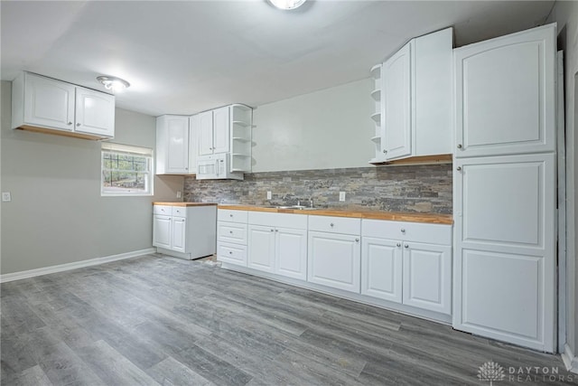 kitchen featuring light wood-type flooring, backsplash, and white cabinetry