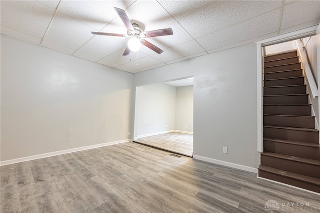 unfurnished room featuring ceiling fan, hardwood / wood-style floors, and a drop ceiling