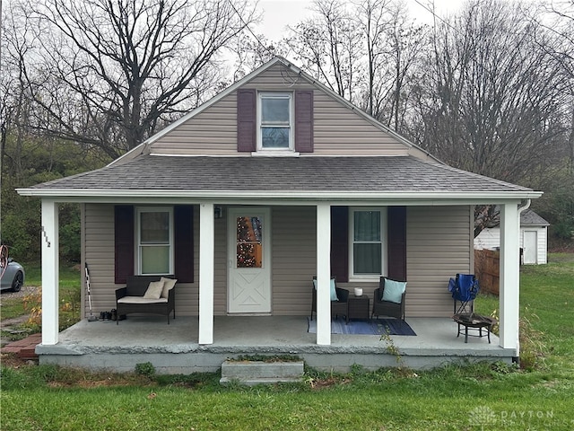 bungalow-style home with a front lawn and covered porch