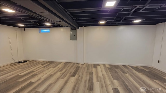 basement with wood-type flooring and electric panel