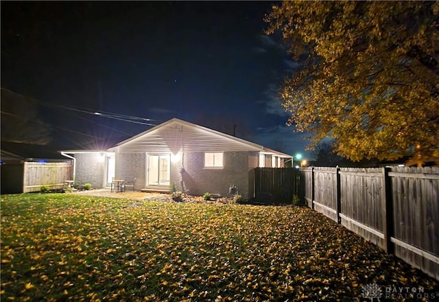 back house at twilight with a yard