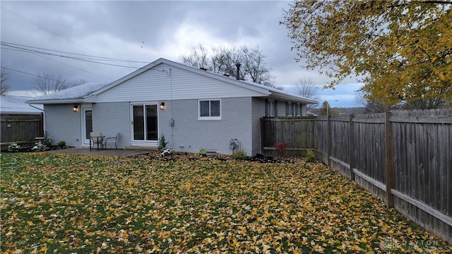 rear view of property featuring a yard and a patio