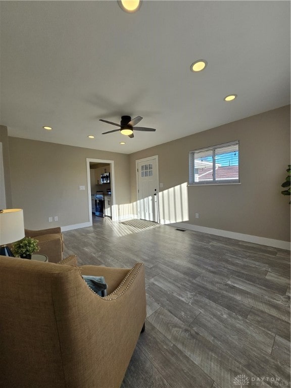 living room featuring ceiling fan and dark wood-type flooring