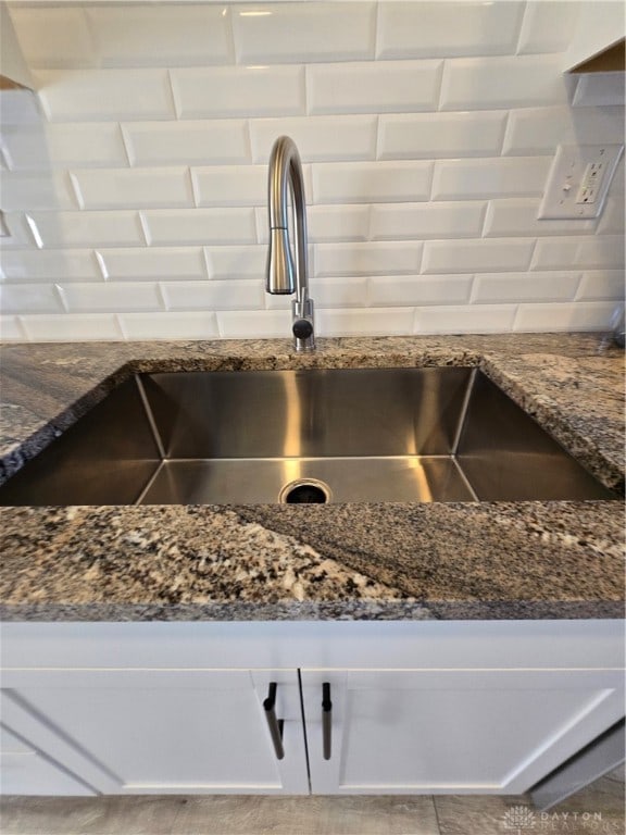 room details with dark stone countertops and sink