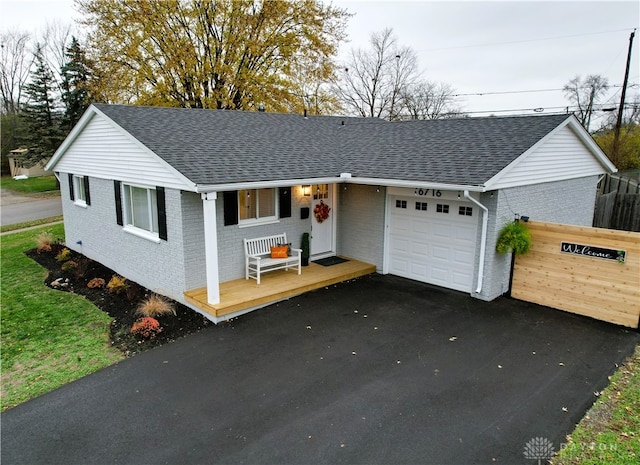 ranch-style house featuring a porch and a garage