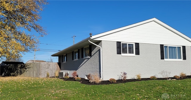 view of side of home featuring a lawn and central air condition unit