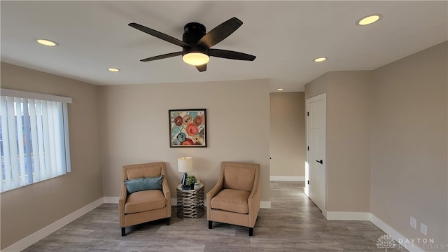 sitting room with hardwood / wood-style floors and ceiling fan