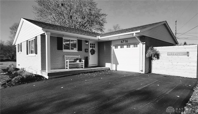 ranch-style home with covered porch and a garage