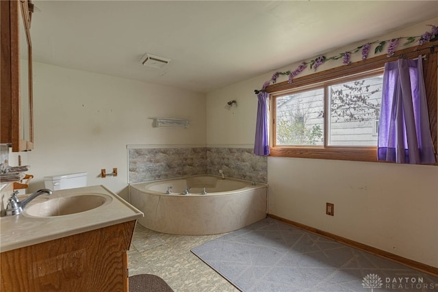 bathroom featuring a tub, vanity, and toilet