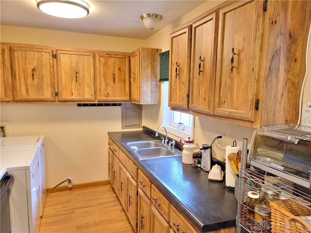 kitchen with washing machine and clothes dryer, light wood-type flooring, and sink