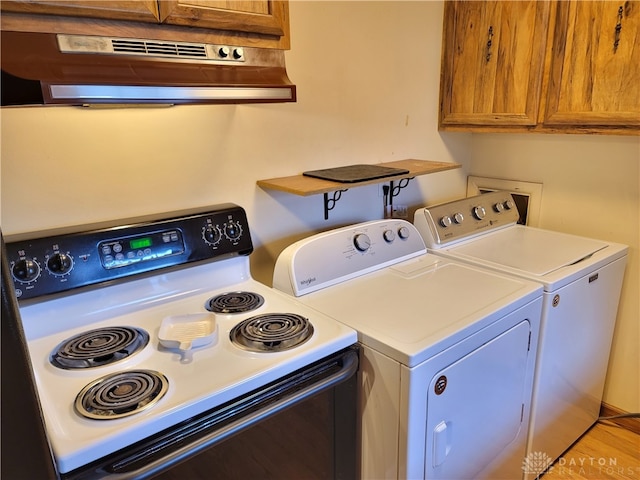 laundry room with light wood-type flooring and washing machine and dryer