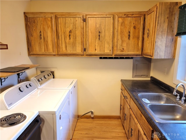 clothes washing area featuring washing machine and clothes dryer, sink, and light hardwood / wood-style flooring