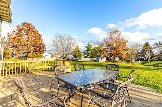 wooden terrace with a lawn and a storage shed