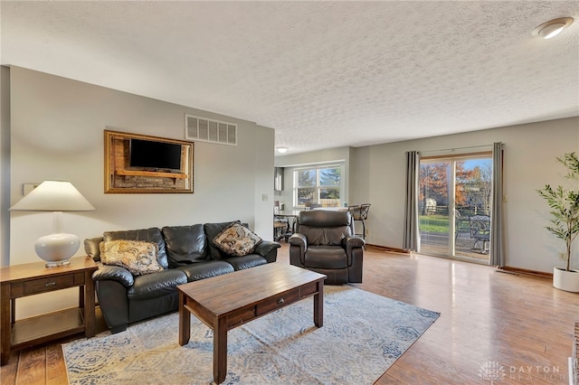 living room featuring light hardwood / wood-style floors and a textured ceiling