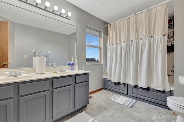 full bathroom with vanity, shower / tub combo, a textured ceiling, and toilet