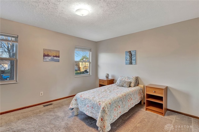 carpeted bedroom featuring a textured ceiling