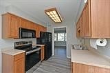 kitchen with black appliances and light hardwood / wood-style flooring