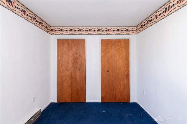 unfurnished bedroom featuring dark colored carpet and baseboard heating