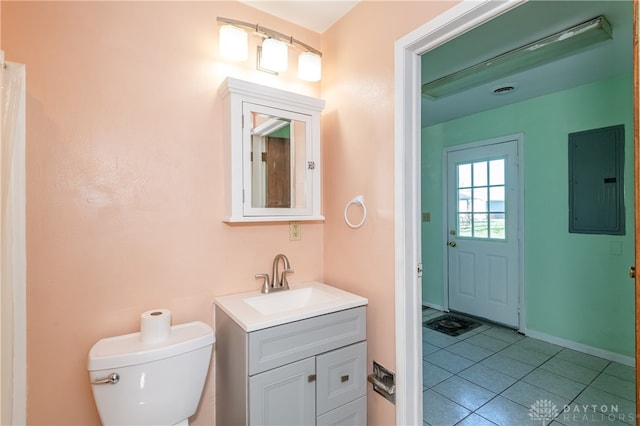 bathroom featuring tile patterned floors, vanity, toilet, and electric panel