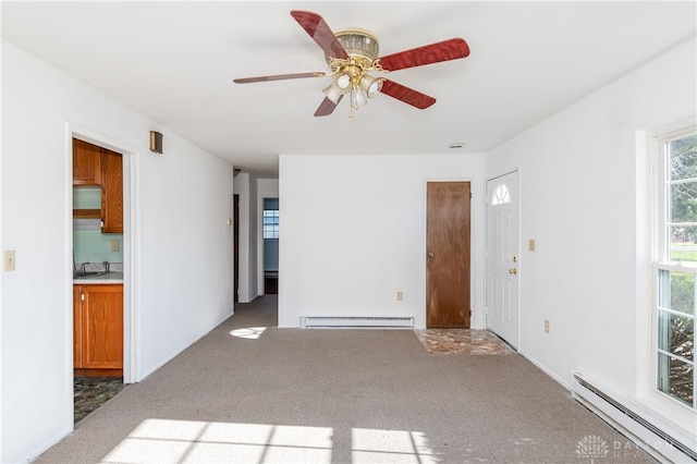 carpeted spare room featuring a baseboard radiator and ceiling fan