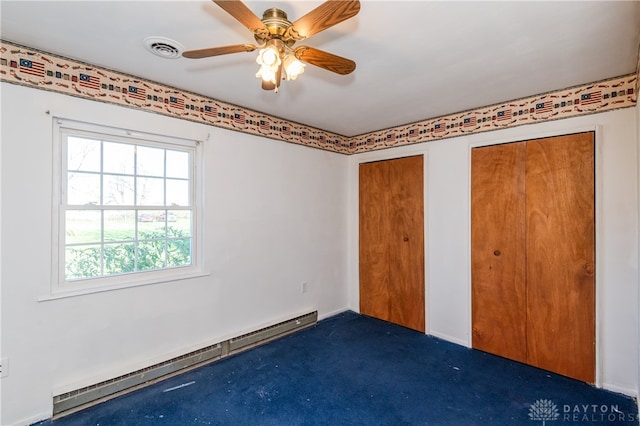 unfurnished bedroom with ceiling fan, a baseboard radiator, two closets, and dark colored carpet