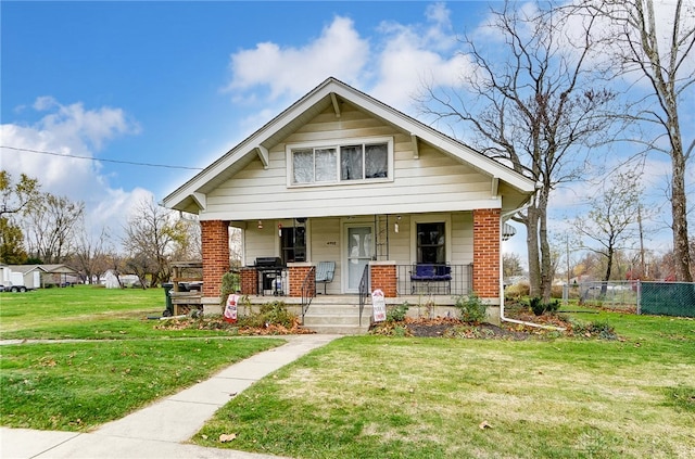 bungalow-style house with covered porch and a front lawn