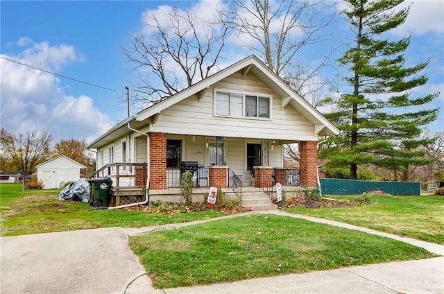 bungalow-style home with covered porch and a front lawn