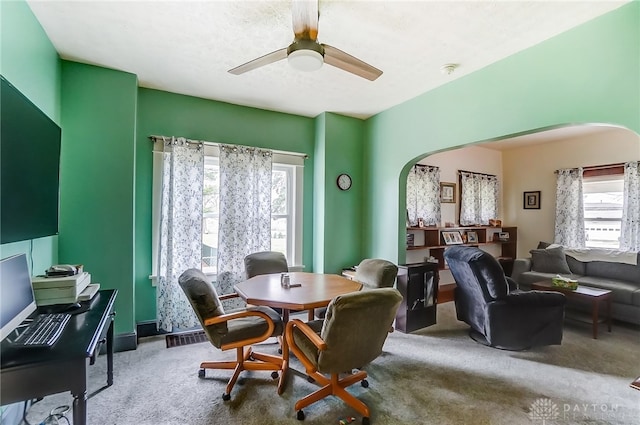 carpeted dining area with ceiling fan