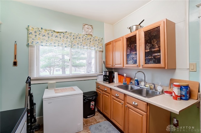 kitchen featuring light tile patterned floors, refrigerator, and sink