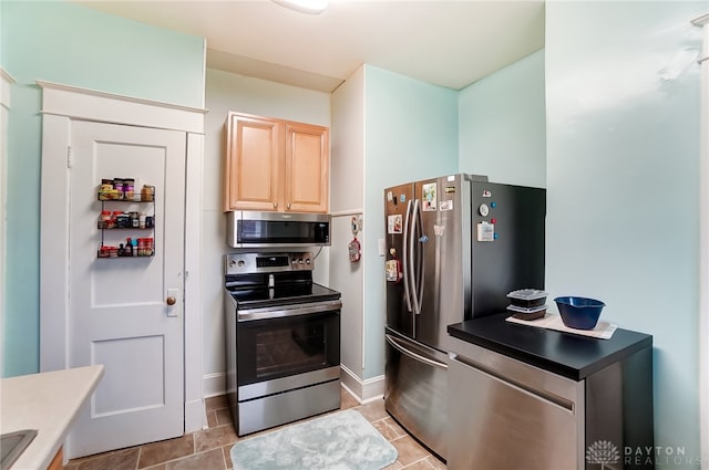 kitchen featuring appliances with stainless steel finishes, light brown cabinets, and light tile patterned floors