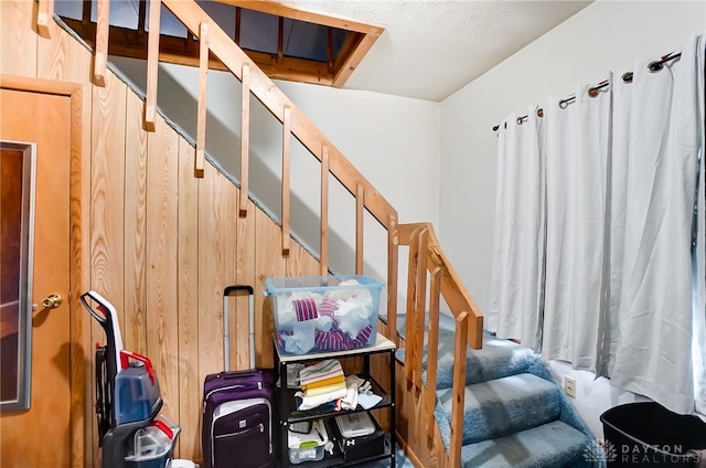 staircase featuring wood walls