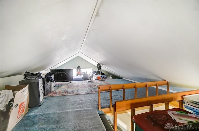 interior space featuring lofted ceiling and dark colored carpet