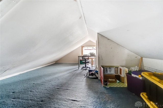 additional living space with lofted ceiling and dark colored carpet