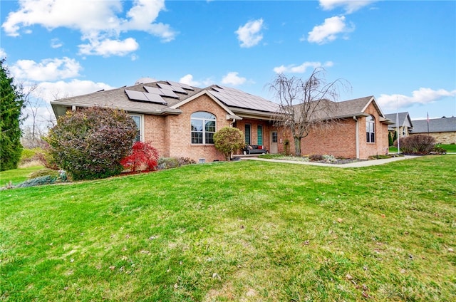 ranch-style house with a front yard and solar panels