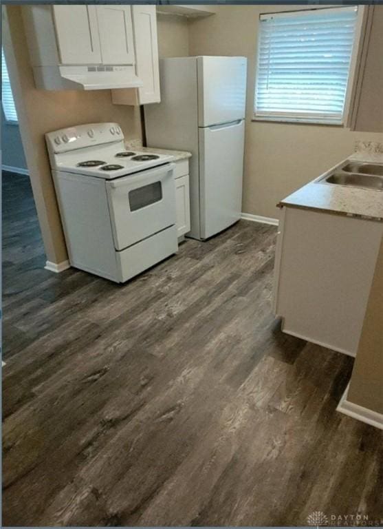 kitchen with dark wood-type flooring, white cabinetry, a sink, white appliances, and under cabinet range hood