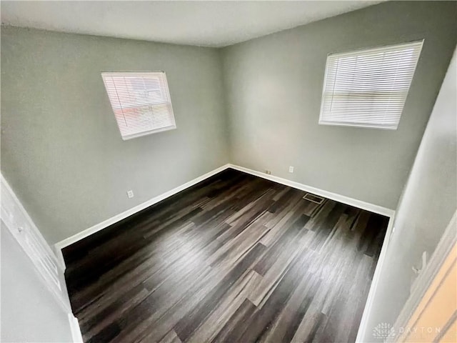 empty room with dark wood-type flooring