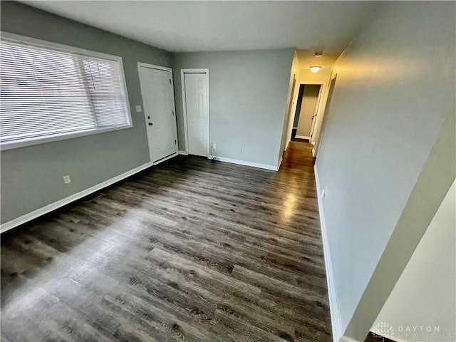 empty room with dark hardwood / wood-style flooring