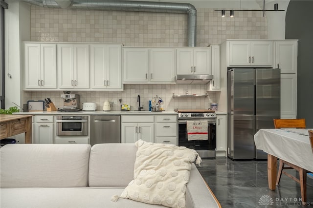 kitchen featuring decorative backsplash, stainless steel appliances, white cabinetry, and sink