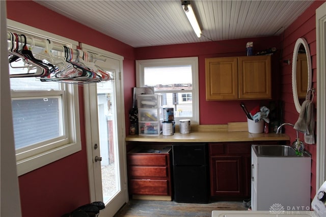 kitchen featuring black refrigerator, light wood-type flooring, and sink