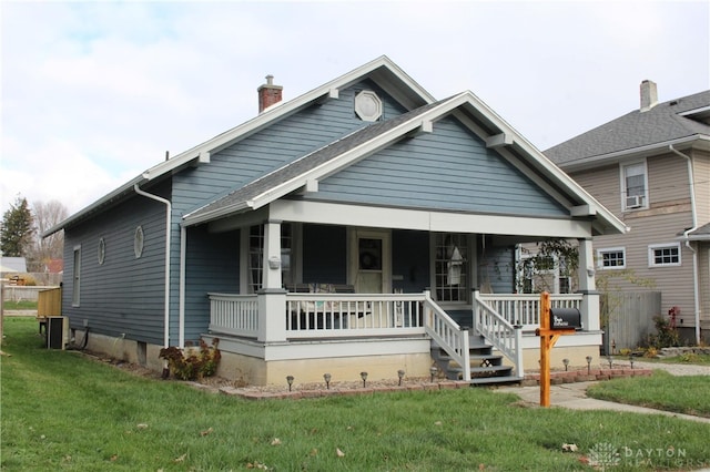 view of front of home with a porch and a front yard