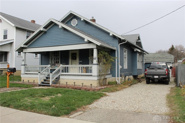 view of front of house featuring covered porch and a front yard