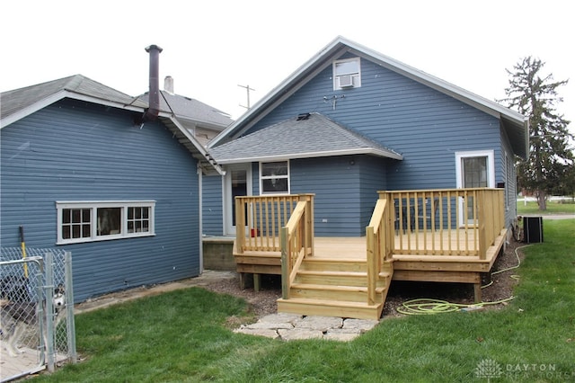 rear view of house with a wooden deck, a yard, and cooling unit