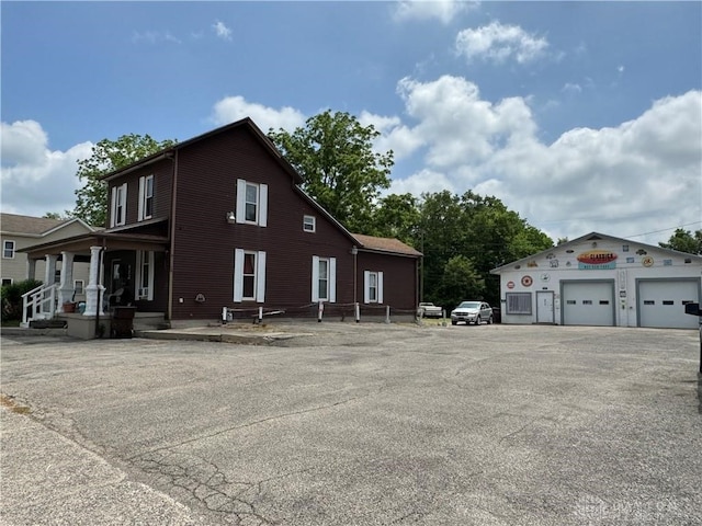 view of side of property with covered porch and a garage