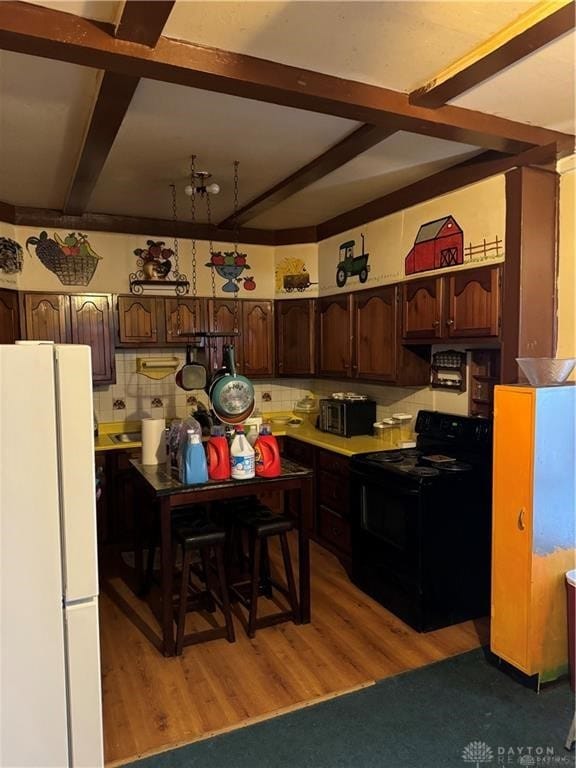 kitchen featuring hardwood / wood-style floors, black electric range oven, backsplash, white refrigerator, and dark brown cabinets