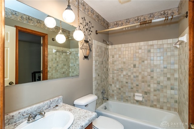 full bathroom with vanity, tiled shower / bath combo, and toilet